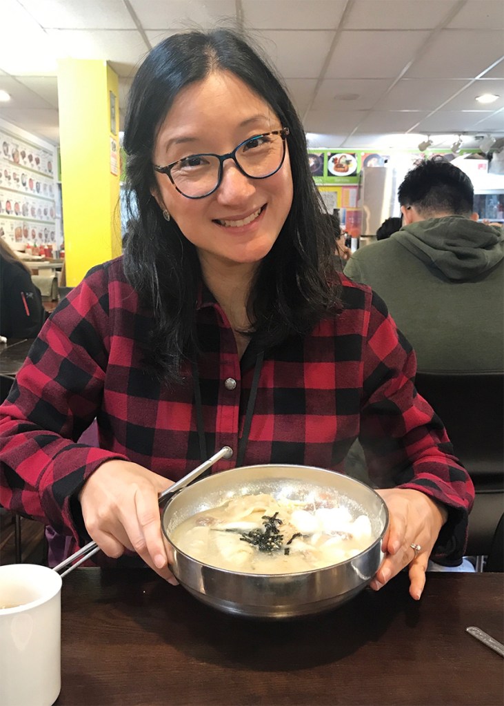 Misty Shock Rule with a bowl of Korean soup at a restaurant